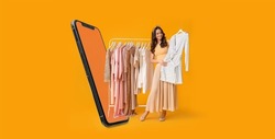 Stylish young woman with stylish clothes on hanger and modern mobile phone on yellow background