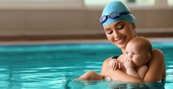 Swimming coach with funny baby in pool