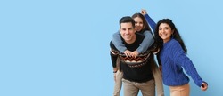 Happy family in warm sweaters on blue background with space for text