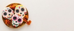 Wooden tray with tasty cookies in shape of skull for Mexico's Day of the Dead (El Dia de Muertos) on light background with space for text
