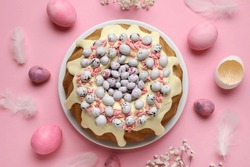 Composition with tasty Easter cake, eggs and gypsophila flowers on pink background