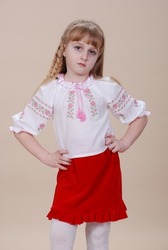 A girl dressed in Ukrainian traditional clothes, vyshyvanka. flowers on the background. Ukrainian little girl.