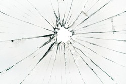 The hole in the broken and cracked glass, closeup 