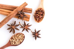 Close up Cinnamon sticks and star anise (badiane) ,coriander seeds, cardamon or sichuan pepper in wooden spoon isolated on white background. Natural herbal plant, spices seasoning conceptual. Top view