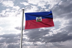 Flag of Haiti waving in the blue sky. National Haiti Flag on Pole.