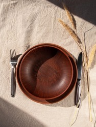 Empty craft handmade clay plate with fork knife linen tablecloth. Table place hand crafted dish. Natural cottagecore styled tableware minimal home interior decor. Restaurant food countryside aesthetic