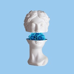 Female antique statue's head with blue flowers roses in the cut isolated on a blue color background. The beauty inside. Trendy collage in magazine surreal style. 3d contemporary art. Modern design