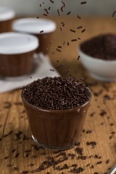 Brazillian chocolate sweet called Brigadeiro in pot on wooden desk background. Vegan version.