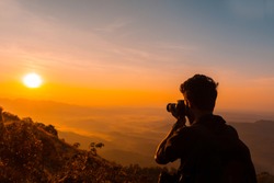 Photographer taking photos of mountains scenery during the sunrise ,beautiful landscape scenery shot from Palakkayam Thattu Kannur, Kerala Travel and Tourism Concept Image, Nature Photography Day