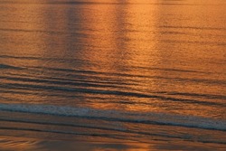 Winter sunset light reflected on gently rippling waters of Atlantic Ocean 