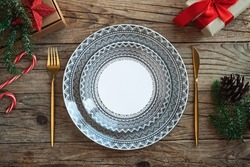 Creative Christmas table setting. Empty plates on rustic wooden xmas background.