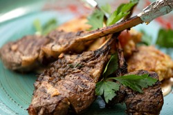 Grilled Meat steak on bone, close up shot. Hearty meat lunch garnished with parsley. Long bone tomahawk rib eye steak. Soft focus. Horizontal format.