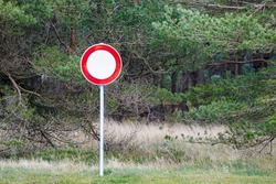 round red and white road sign is forbidden to drive on a green forest background