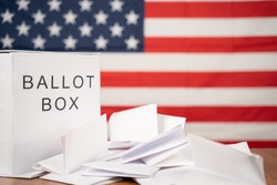 Ballot Box with votes on table before counting with US flag as background concept of Ballot or vote Counting after US election.