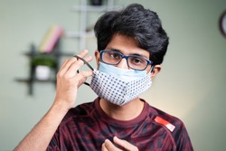 Portrait Young man wearing double or two face mask to protect from coronavirus or covid-19 outbreak - concept of safety, healthcare, medical and hygiene.