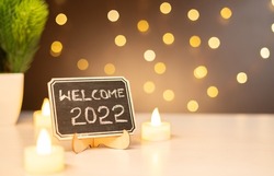 concept of 2022, - closeup shot of welcome 2022 sign board decorated party lighting background - concept of celebrating New Year and Copy space