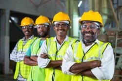 Confidently standing industrial workers with arms crossed by looking at camera - concept of workforce, occupation and safety