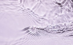 Blurred or defocused transparent  clear  water. Purple liquid colored clear water surface texture with splashes bubbles and  leaf shadows. Trendy  nature background. 

