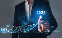 Businessman draws  increase arrow graph corporate future growth year 2021 to 2022.   Development to success and motivation.