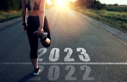 Sporty girl who runs towards year 2023, leaving behind the year 2022. New year 2023 with new ambitions, plans, goals and visions.