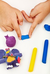 Child hands playing with colorful clay - closeup
