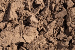 clods of plowed land, dark background texture, field ready for planting, copy space