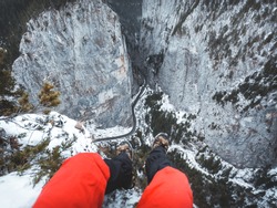 Personal perspective of hiker legs hanging above the cliff. Adventure time above Bicaz Gorge, Romania