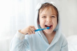 Morning routine, smiling happy child brushing teeth with toothbrush. Dental hygiene of little boy, medical care.