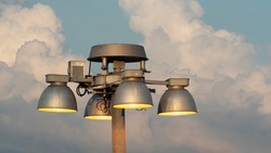 Airport ramp light chandelier against blue sky and clouds
