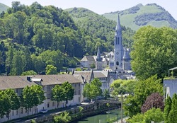 The Sanctuaire Notre Dame is within a magnificent setting below the Pyrenes mountains and beside the river gave du pau.
