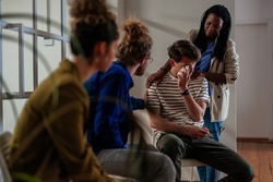 Support group multiracial patients comforting man at therapy session