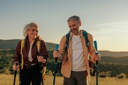 Middle age couple hiking and going camping in nature. Concept of choosing of a right path at the wildlife area.
