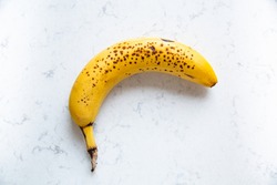 Ripe banana on a marble kitchen counter.