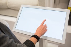 A woman touching the screen of self service device in the store.