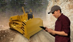 Man controls autonomous bulldoser using digital tablet