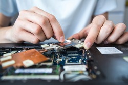 Computer literacy repair men hands, man examines laptop clean thermal paste