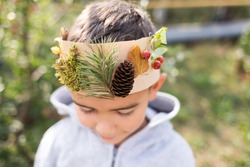 boy wearing a crown made of natural materials, late summer or autumn crafts