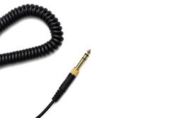 Stereo audio headphone jack with cable on white background. Gold jack plug for connecting audio devices and musical instruments. Electrical connector for analog audio signals.