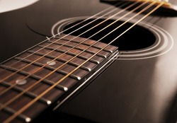 black acoustic guitar and strings close up, studio light