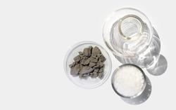 Aluminium powder in Chemical Watch Glass place next to Cetyl esters wax in glass container and Flat Bottom Flask. Top View
