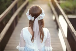 Young girl in white communion dress with a beautiful hairstyle.