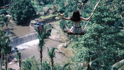 Female tourists swinging on beautiful natural place in Ubud, Bali, Indonesia.
