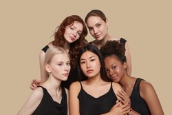 The real beauty exists in every corner of the world and is presented by women of all races. Group portrait of five beautiful ladies in black tops and with different skin and hair colour.