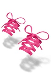 Subject shot of pink shoe strings with thin tips. Flat shoe laces are tied in bows and hanging in the air on the white background. 