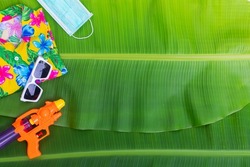 Songkran Festival background image Water play equipment on green wet banana leaf