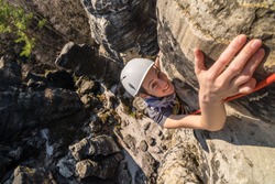 Happy active young girl rock climbing on sandstone towers - reaching the summit, Tisa sandstone rocks, Usti nad Labem region, Czech republic