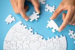 Businessman hand connecting jigsaw puzzle, Business solutions,  target, success, goals and strategy concepts 