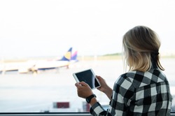 MAY 5 2016 - BUDAPEST, HUNGARY: woman looking at tablet and ryanair airplane at airport 