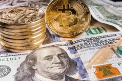 Crypto Bitcoin One dollar bitcoin, virtual money and one hundred dollar banknotes. Bitcoins on US dollars. Dollar to bitcoin exchange. Background with crypto bitcoins and dollars. Golden bitcoin