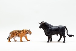 Plastic tiger and bull figurines close-up. The year of the bull is leaving , the year of the tiger is coming. The symbol of 2022 is a tiger